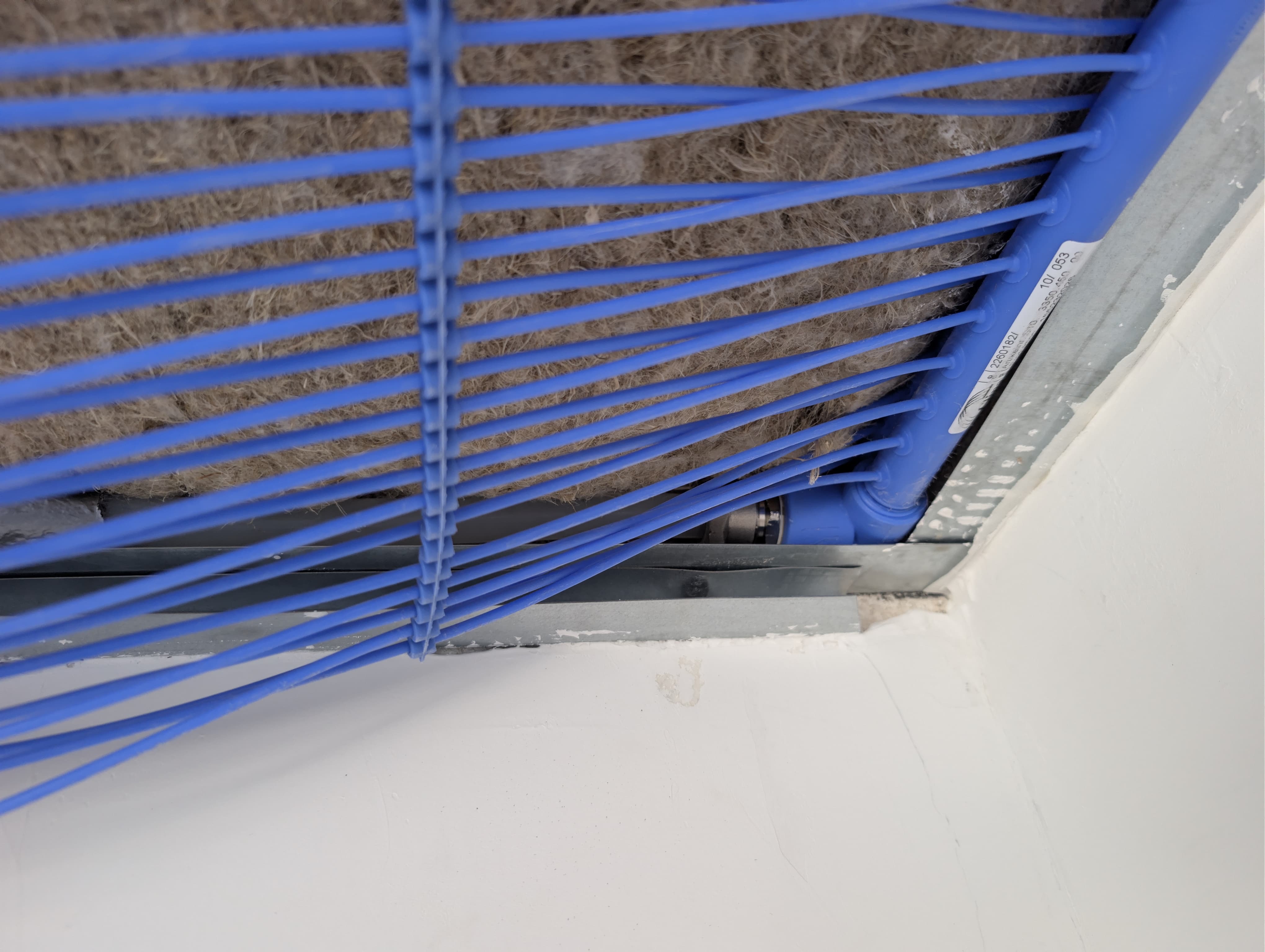 Blaue Kühlleitungen in einer geöffneten Deckenkonstruktion